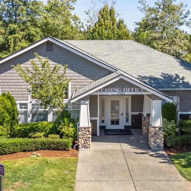 Visually pleasing leasing office building surrounded by greenery.