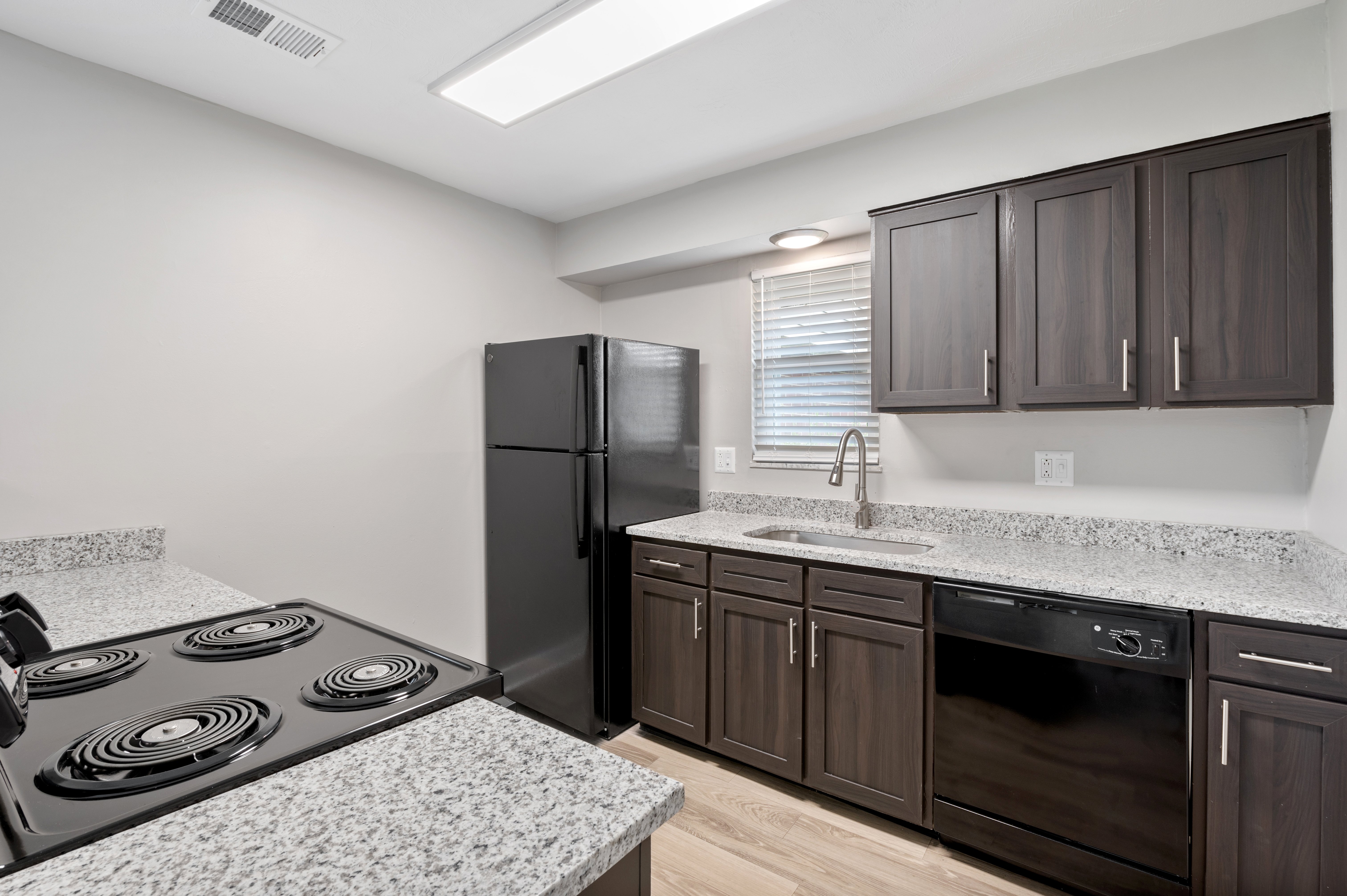 Contemporary Kitchen Interior Modern kitchen with dark cabinets, granite countertops, and black appliances.