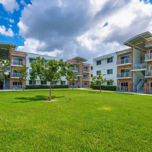 Grass courtyard with tree's surrounded by the apartment buildings at Princeton Groves.