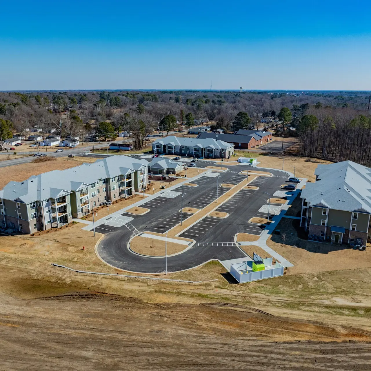 Aerial view of a newly constructed apartment complex featuring multiple buildings and a parking lot