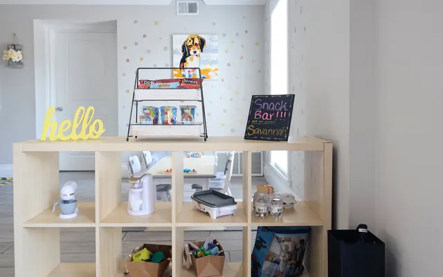 A colorful interior space featuring a snack bar display and a friendly greeting.
