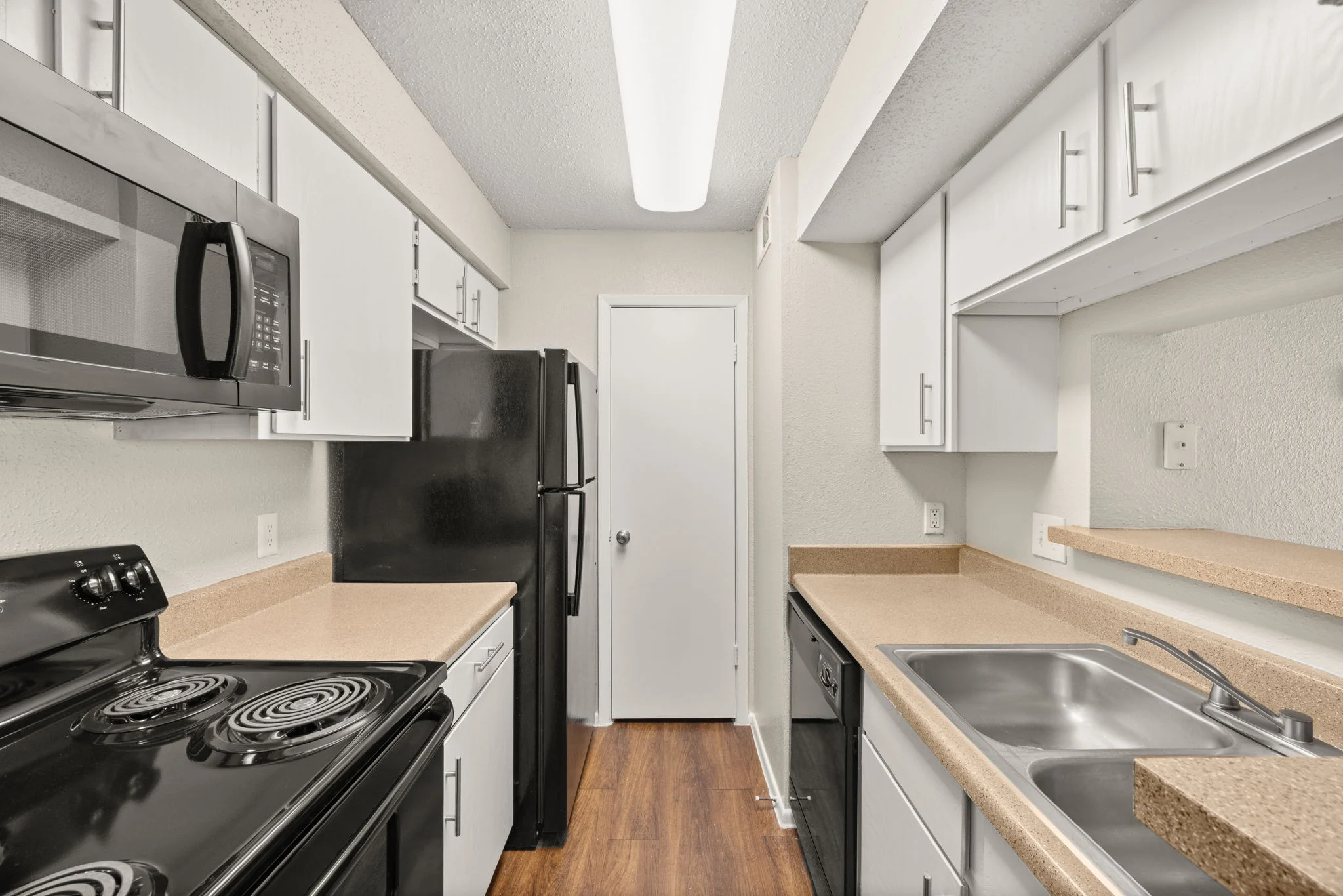 Modern Kitchen Interior Interior of a modern kitchen featuring a black stove, microwave, refrigerator, and a sink.