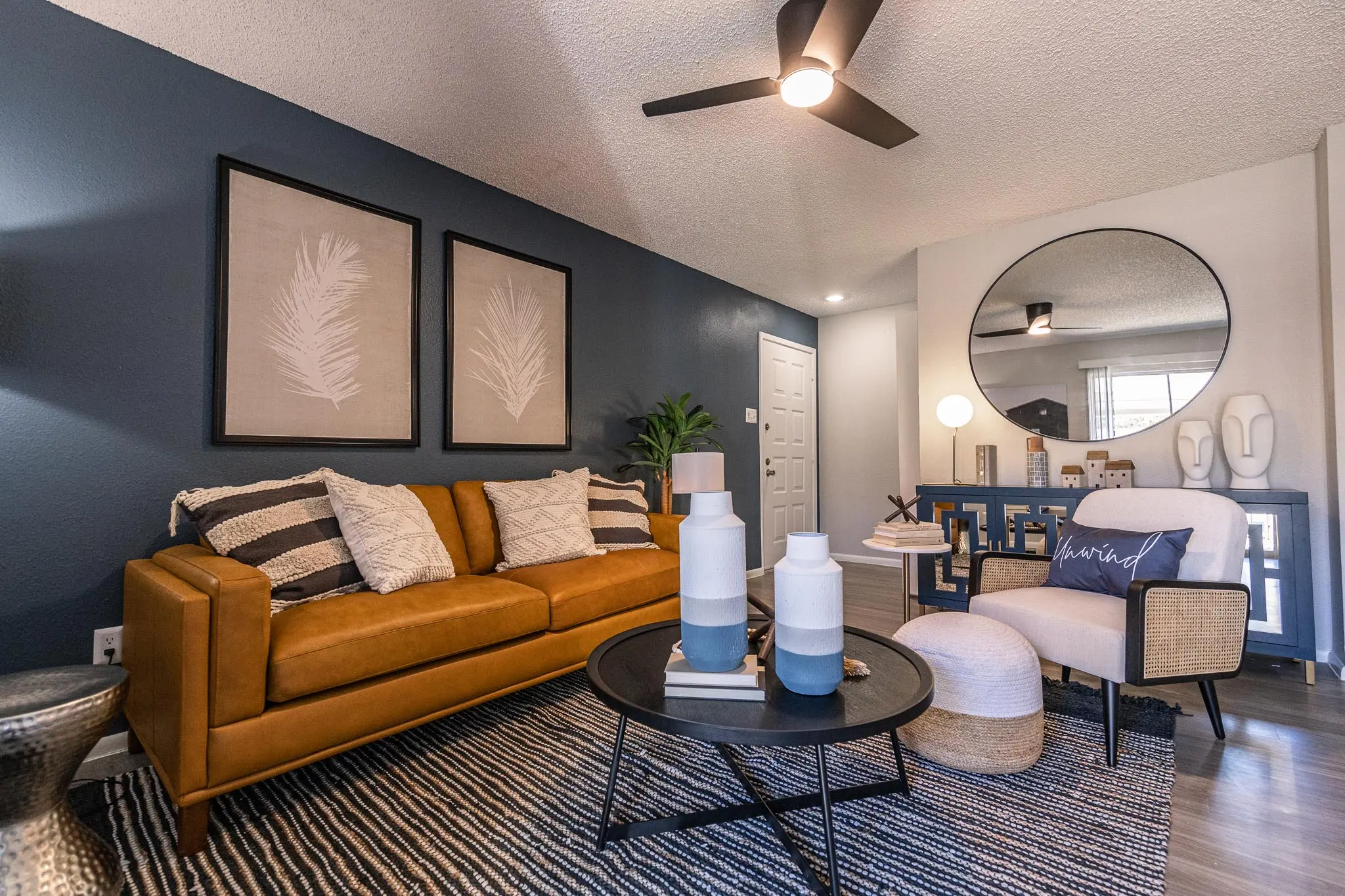 Furnished living room that includes hardwood-style flooring, ceiling fan, and light, navy blue and white walls
