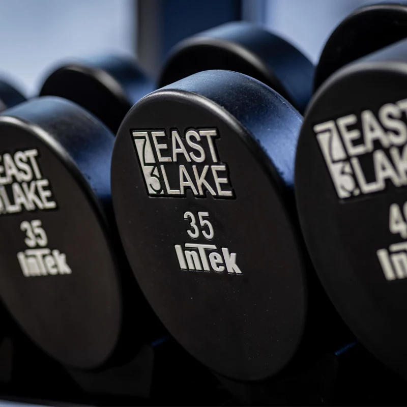 A close-up view of a set of black dumbbells labeled with weights of 35 and 40 pounds, featuring the text 'EAST LAKE' and 'InTek' on them.