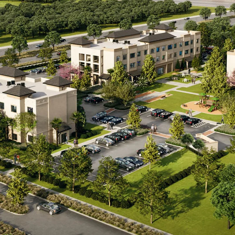 Aerial view of a modern apartment complex surrounded by trees and parking lots