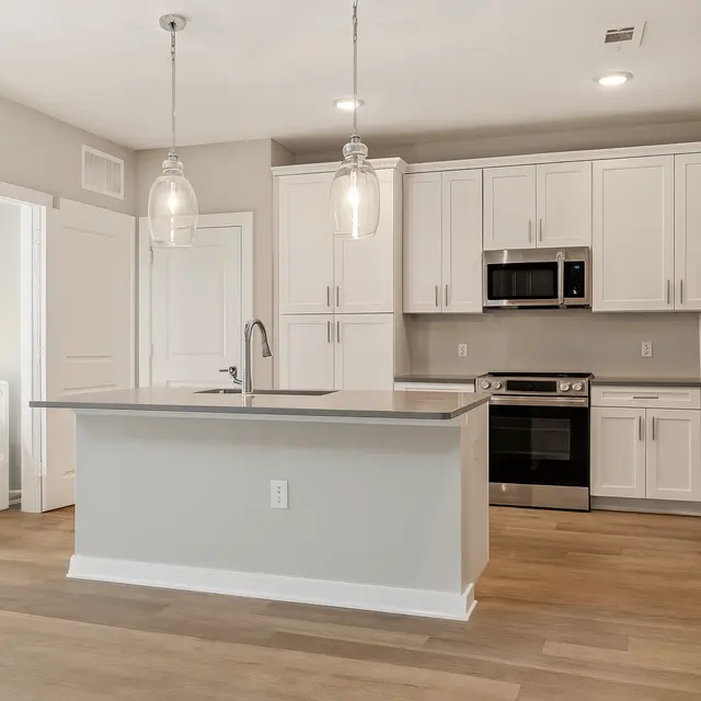 Modern Kitchen Design A modern kitchen featuring white cabinetry, stainless steel appliances, and pendant lighting above a central island.