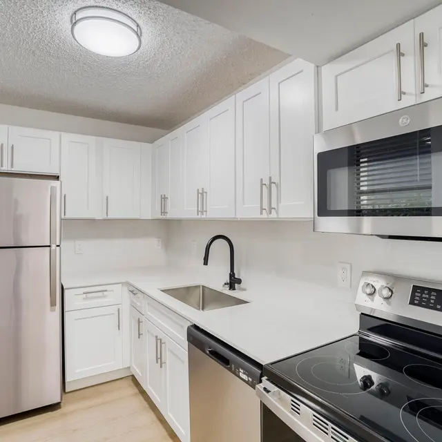 Modern Kitchen Design A modern kitchen featuring white cabinetry, stainless steel appliances, and a sleek design with a light wood floor.