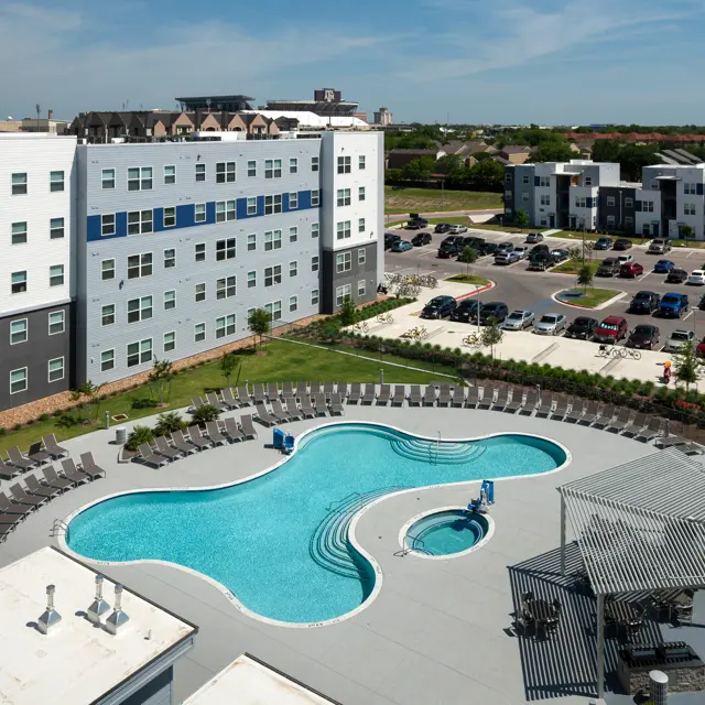 1 Bedroom Student Apartments in College Station TX | Park West | Exterior Shot of the Swimming Pool and Spa Surrounded by Lounge Chairs and Seating