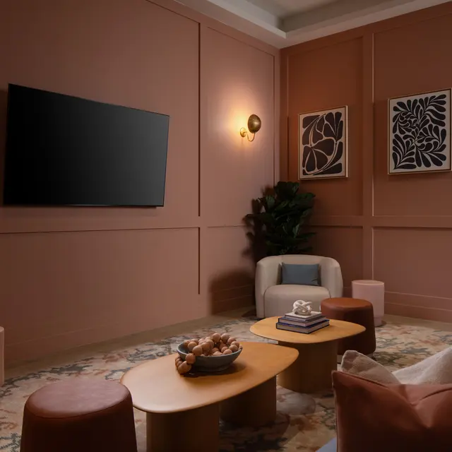 A cozy living room with a warm, earthy color palette featuring a mounted TV, comfortable seating, and stylish decor.