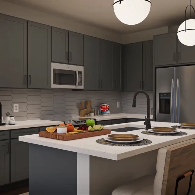 A modern kitchen featuring dark gray cabinetry, a large island with bar stools, and a stylish countertop decorated with a fruit platter and plates. The kitchen includes stainless steel appliances and decorative lighting fixtures.