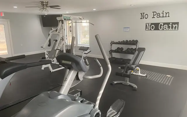 A modern gym interior featuring workout equipment including cardio machines and weights.