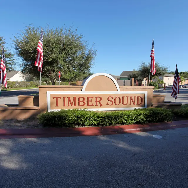 Entrance sign of Timber Sound community with American flags