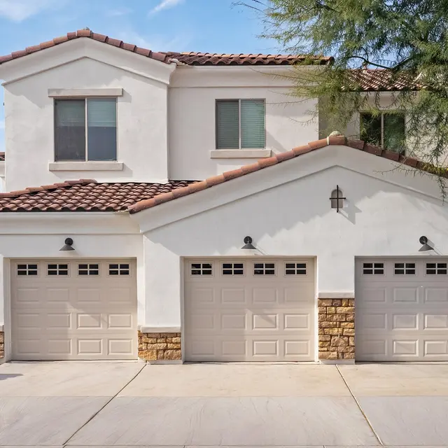 Exterior view of a modern two-story home with three garage doors.