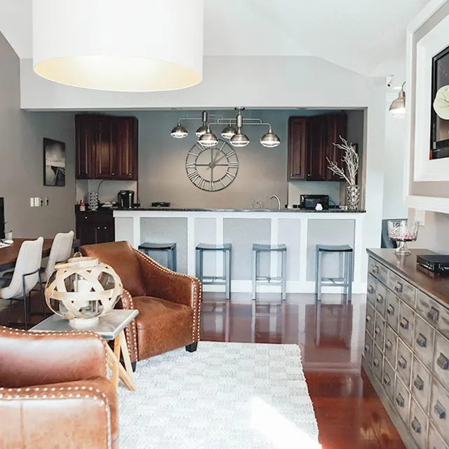Furnished living room looking towards the open kitchen island, countertops, and barstools. 