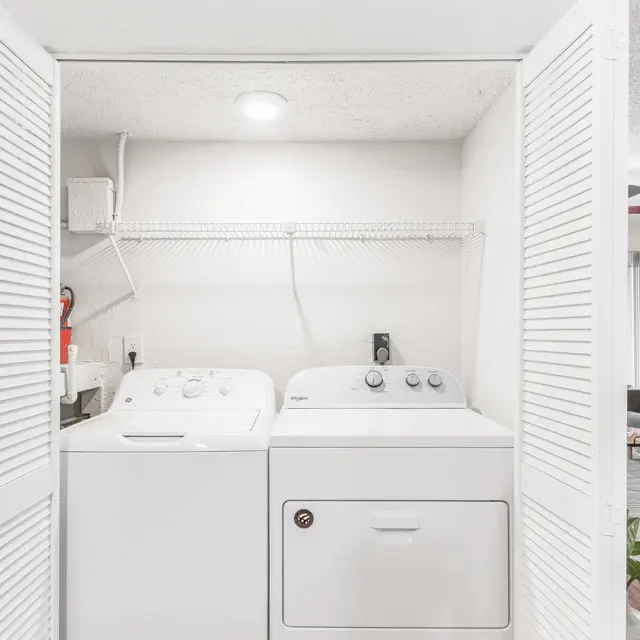 Portofino Club In-unit washer and dryer inside of spacious closet between the kitchen and living area.