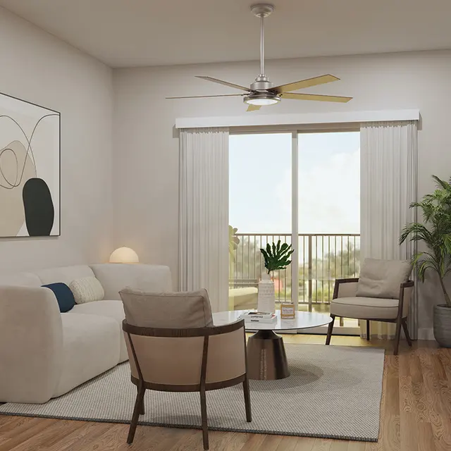 A modern living room featuring a white sofa, wooden floors, and large windows with sheer curtains. The space is decorated with a piece of abstract art, a circular coffee table, and two upholstered chairs. A potted plant adds a touch of greenery, and there's a TV on a wooden console opposite the seating area.