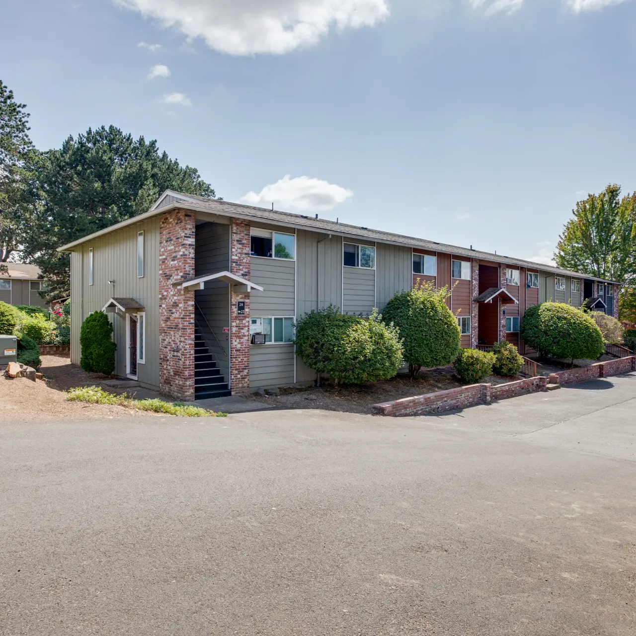 Apartment Complex Landscape View of a residential apartment complex with landscaped hedges and trees.