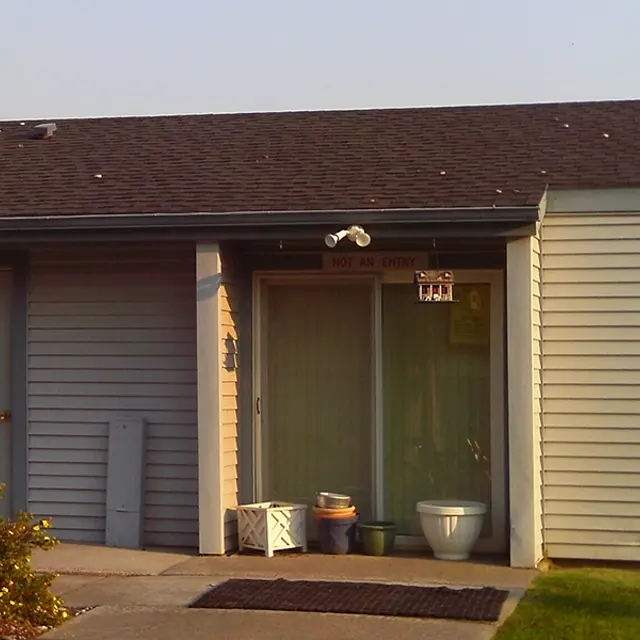 Leasing Office Exterior Exterior view of a leasing office with a sign indicating office hours and a large window.