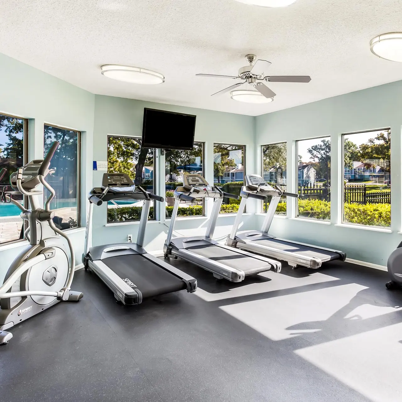 fitness center with tons of windows overlooking the pool deck
