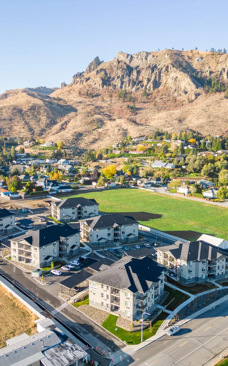 Aerial view of the Landing at Saddlerock apartment complex in Wenatchee, WA, showcasing its layout and surrounding environment, including mountains