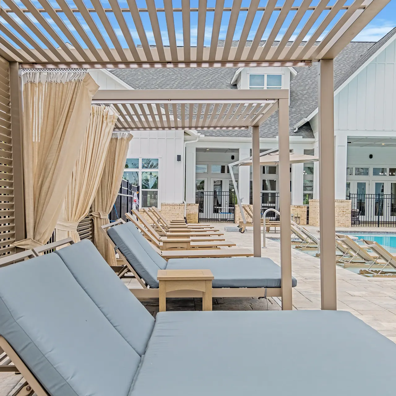 outdoor lounge furniture under the cabanas by the pool
