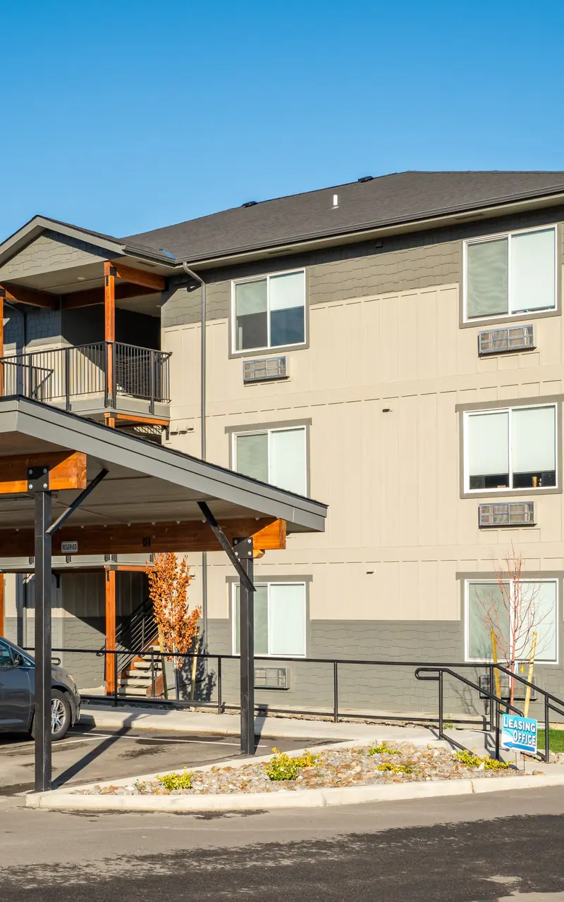 Covered carport with space for multiple vehicles, featuring a sturdy roof and open sides for easy access and protection from the elements.