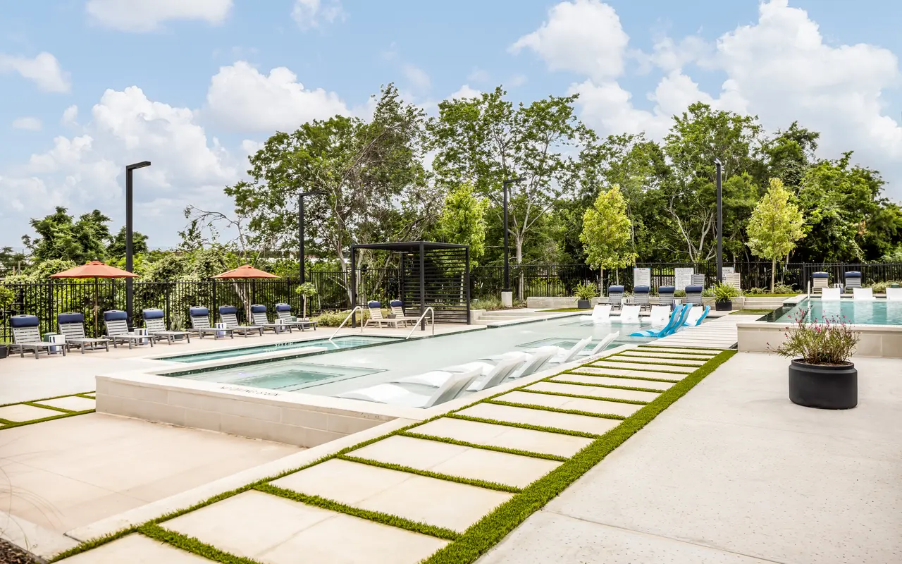 Resort-style pool at Aviva at Standard on the River with sun loungers, umbrellas, and private cabanas.