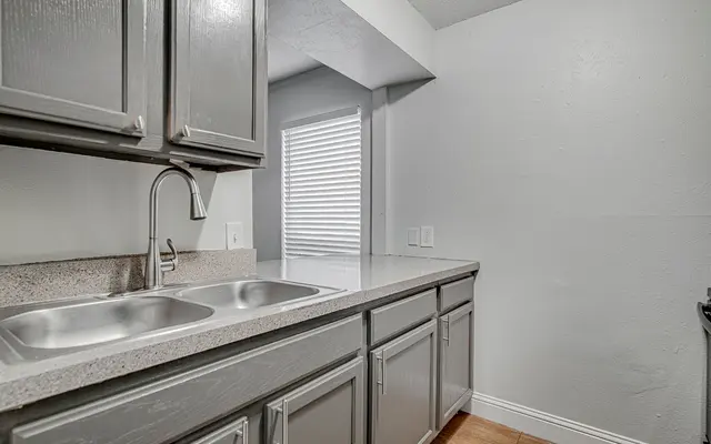 Kitchen with Sink, grey cabinets and wood flooring