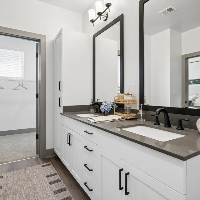 Modern Bathroom Design A modern bathroom featuring dual sinks, large mirrors, and a spacious closet area with hooks.