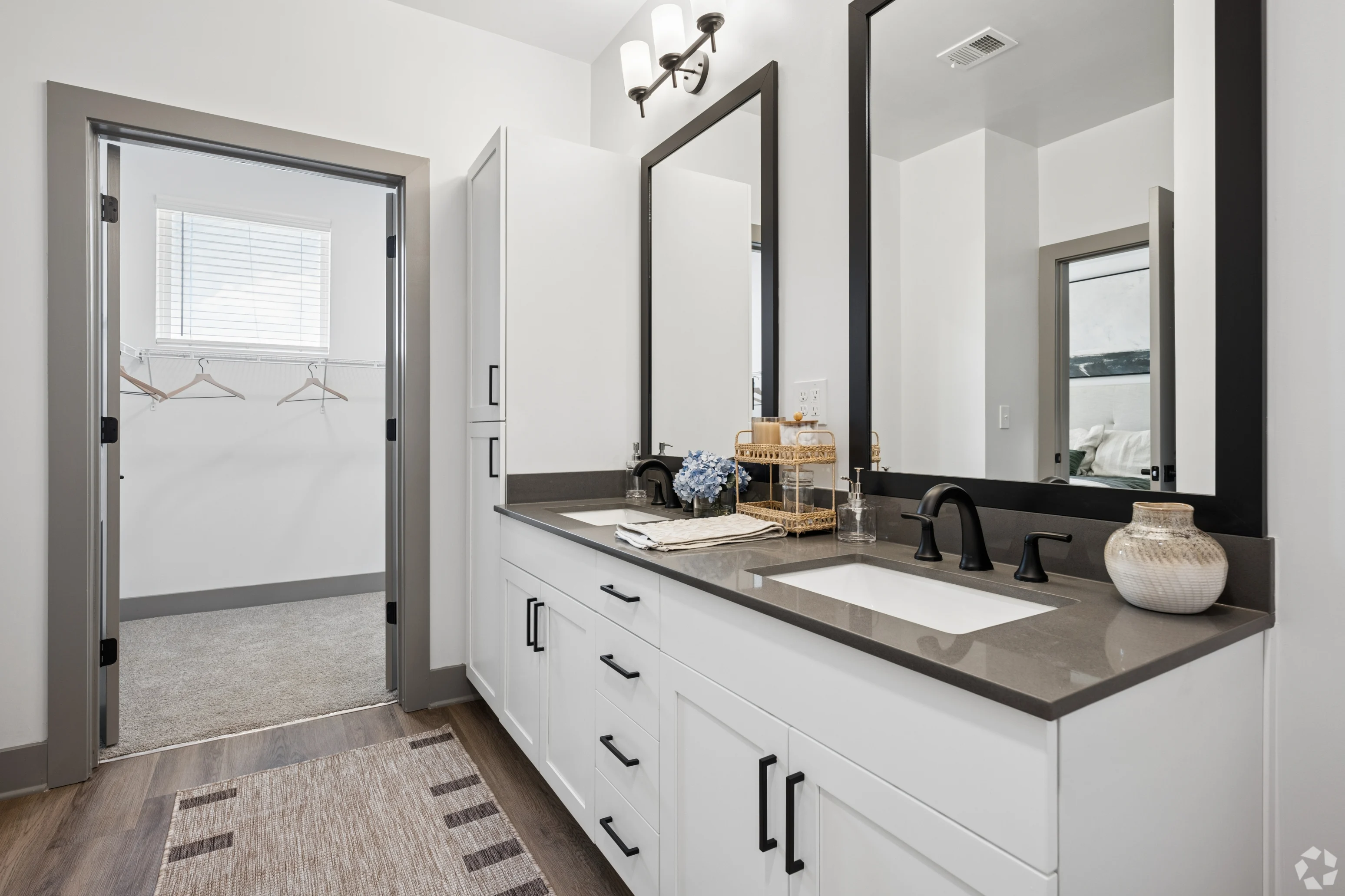 Modern Bathroom Design A modern bathroom featuring dual sinks, large mirrors, and a spacious closet area with hooks.