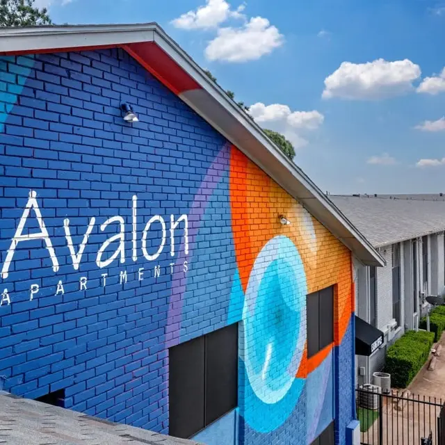 Avalon Apartments Exterior Exterior view of Avalon Apartments featuring a colorful mural on the wall with blue, orange, and purple tones.