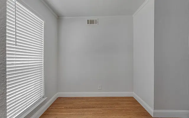 Unfurnished room with wood flooring and white walls