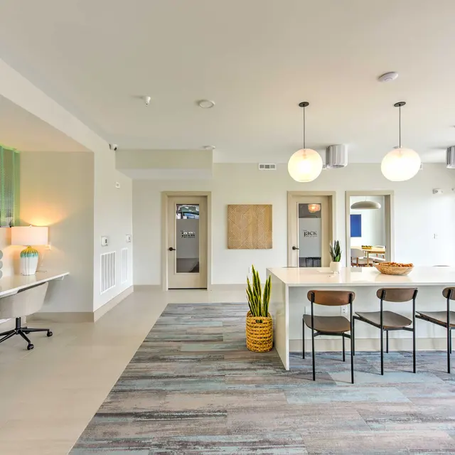 Contemporary Communal Workspace A modern indoor space featuring a communal work area with chairs, a long countertop, and decorative elements.