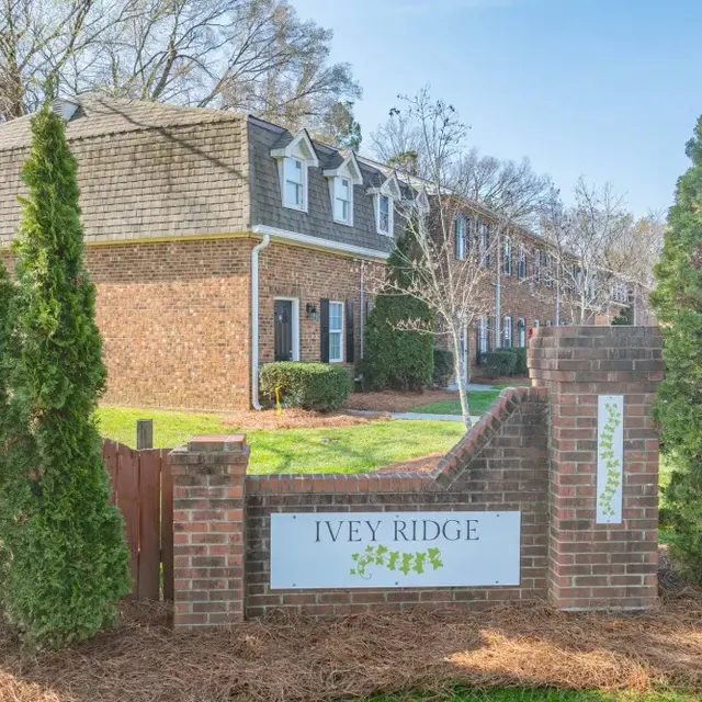 Exterior view of the Ivey Ridge apartment complex entrance, featuring brick signage and landscaped greenery.