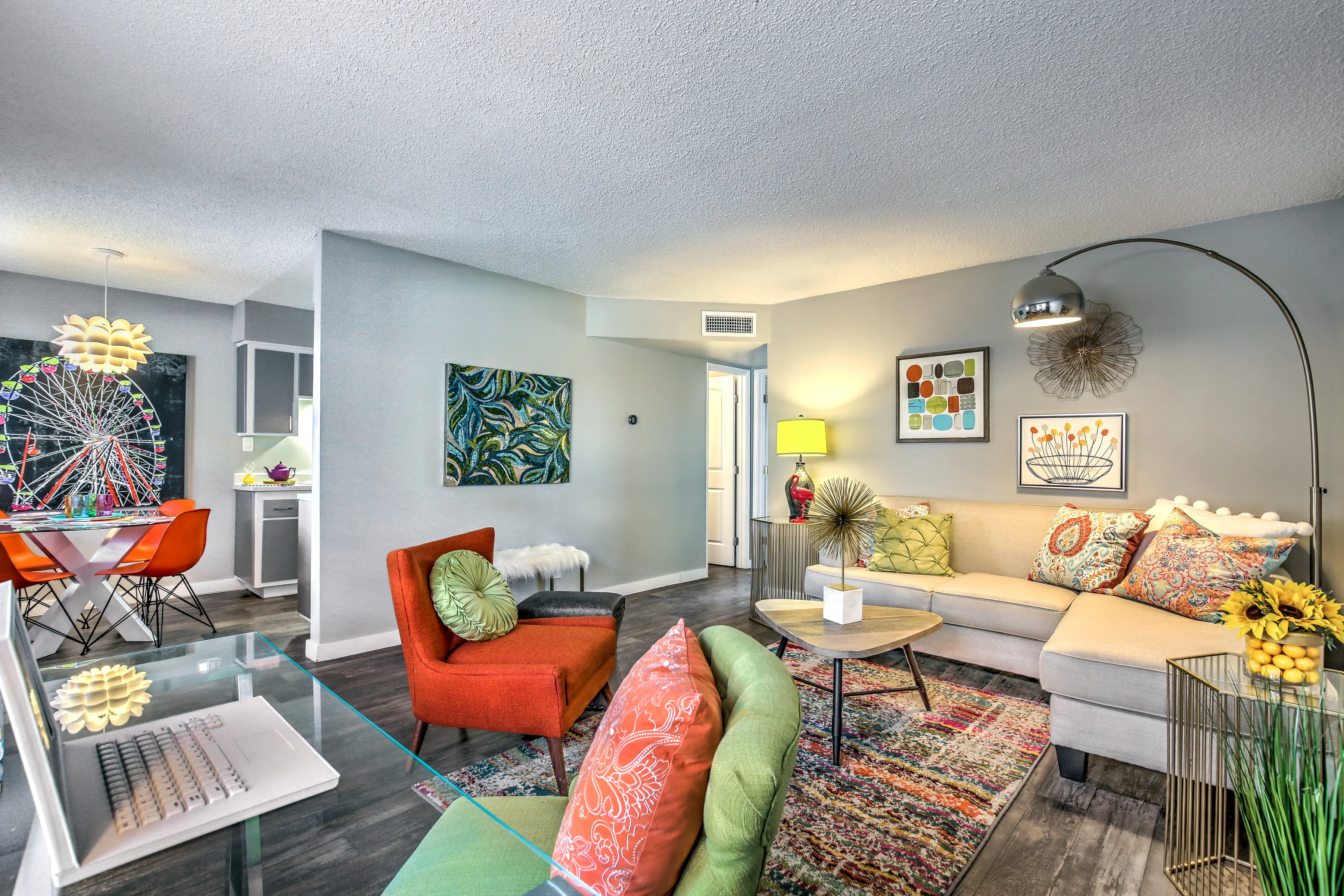 Vibrant Modern Living Room A vibrant living room featuring a modern sofa, colorful pillows, and stylish decor. A dining area is visible in the background with a contemporary light fixture and a round table with bright chairs.