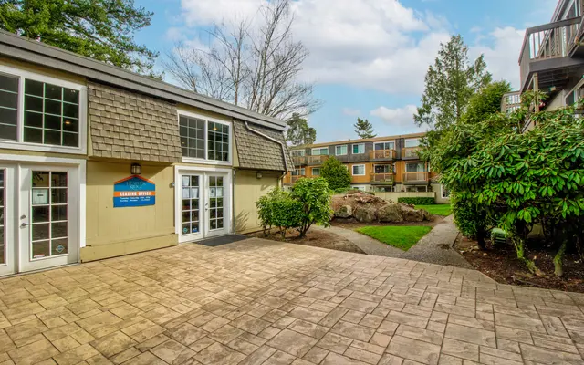 Courtyard with Outdoor Landscaping Outdoor area featuring a stone path, greenery, and building with large windows.