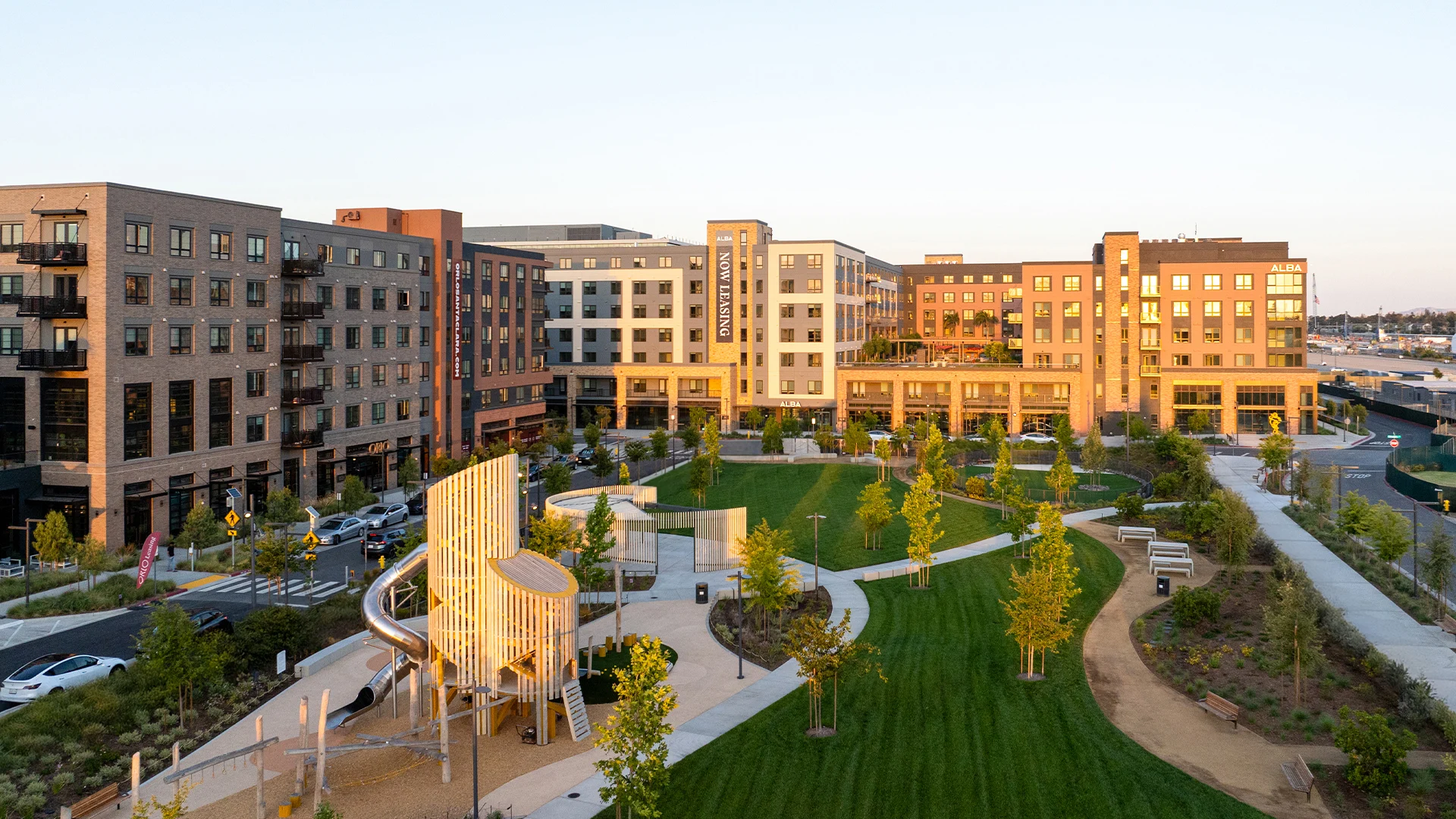 Modern Apartments with Park A view of modern apartment buildings with greenery and a park area.