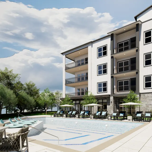 A modern apartment building viewed from the pool area, with trees and cloudy sky in the background.