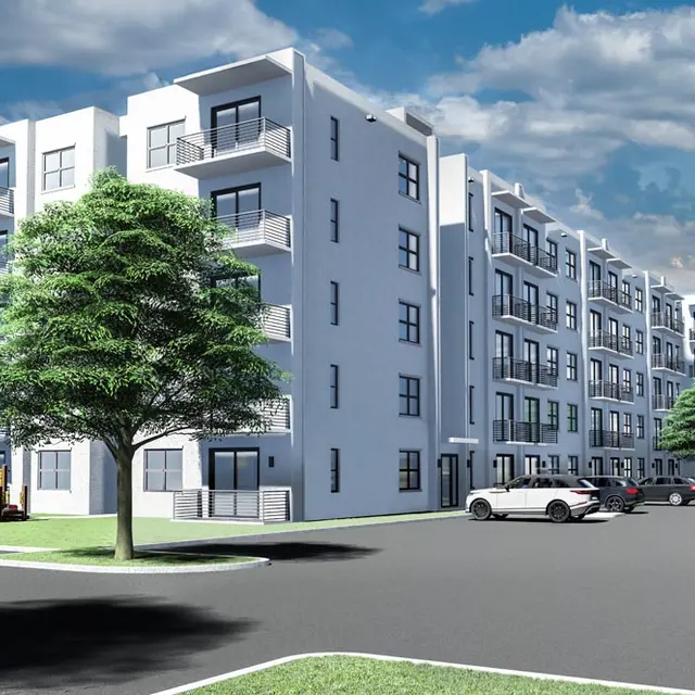 A modern apartment complex with a playground and cars in the parking area.
