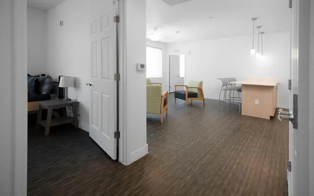 Stylish Modern Apartment Interior A spacious modern apartment interior with a living area and kitchen, showcasing a wooden floor and bright lighting.