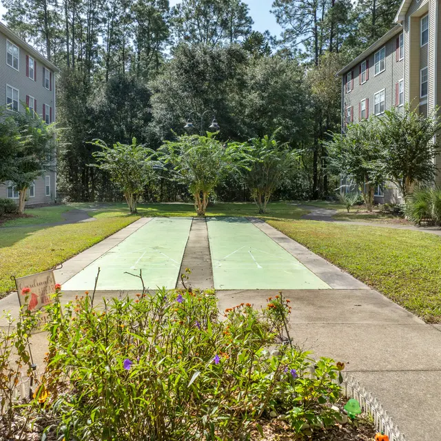 View of a garden area between two apartment buildings featuring green grass and walkways