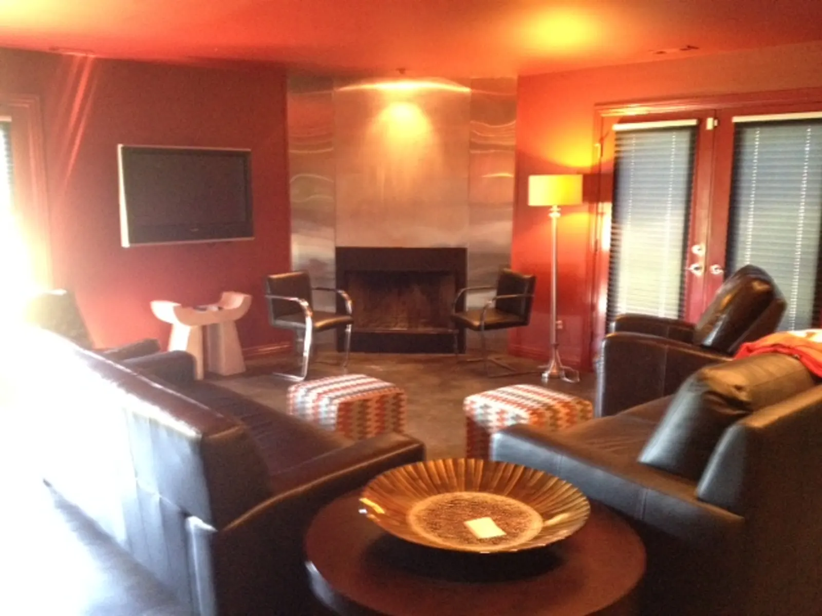 Two black doors with glass panels are set into a gray, horizontal siding wall. A fenced area is visible on the left.