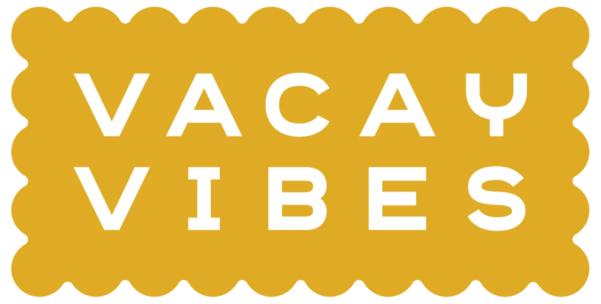 A logo featuring the words 'VACAY VIBES' in bold white font on a yellow scalloped background.