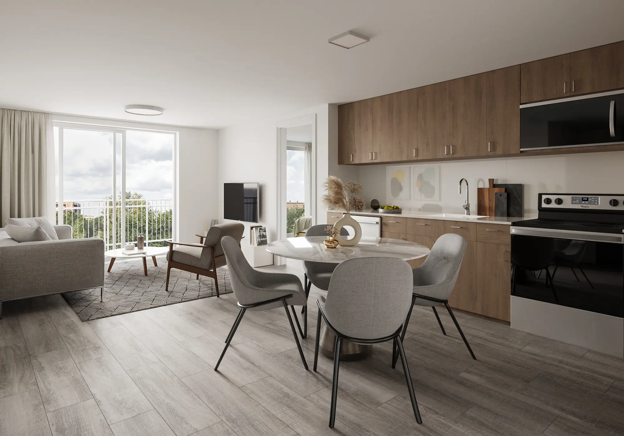 A modern apartment interior featuring a kitchen and dining area, with light wood cabinetry and a comfortable living space that includes a gray couch, dining table, and large windows allowing natural light.