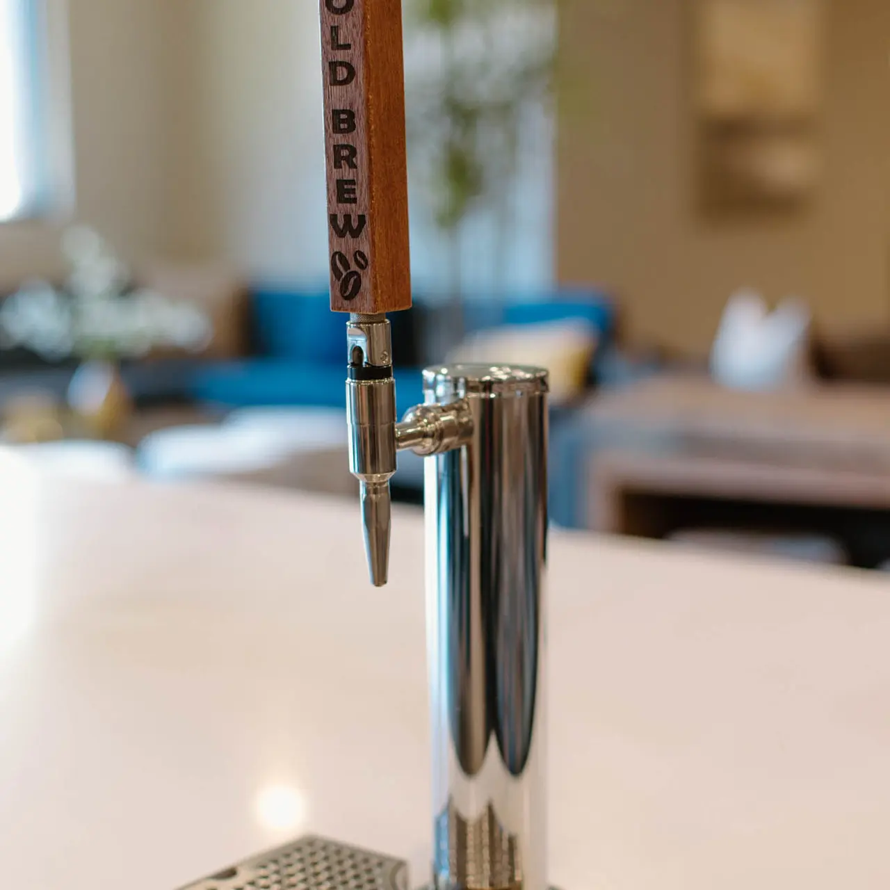 A cold brew coffee dispensing system featuring a polished metal tap with a wooden handle labeled 'COLD BREW'.