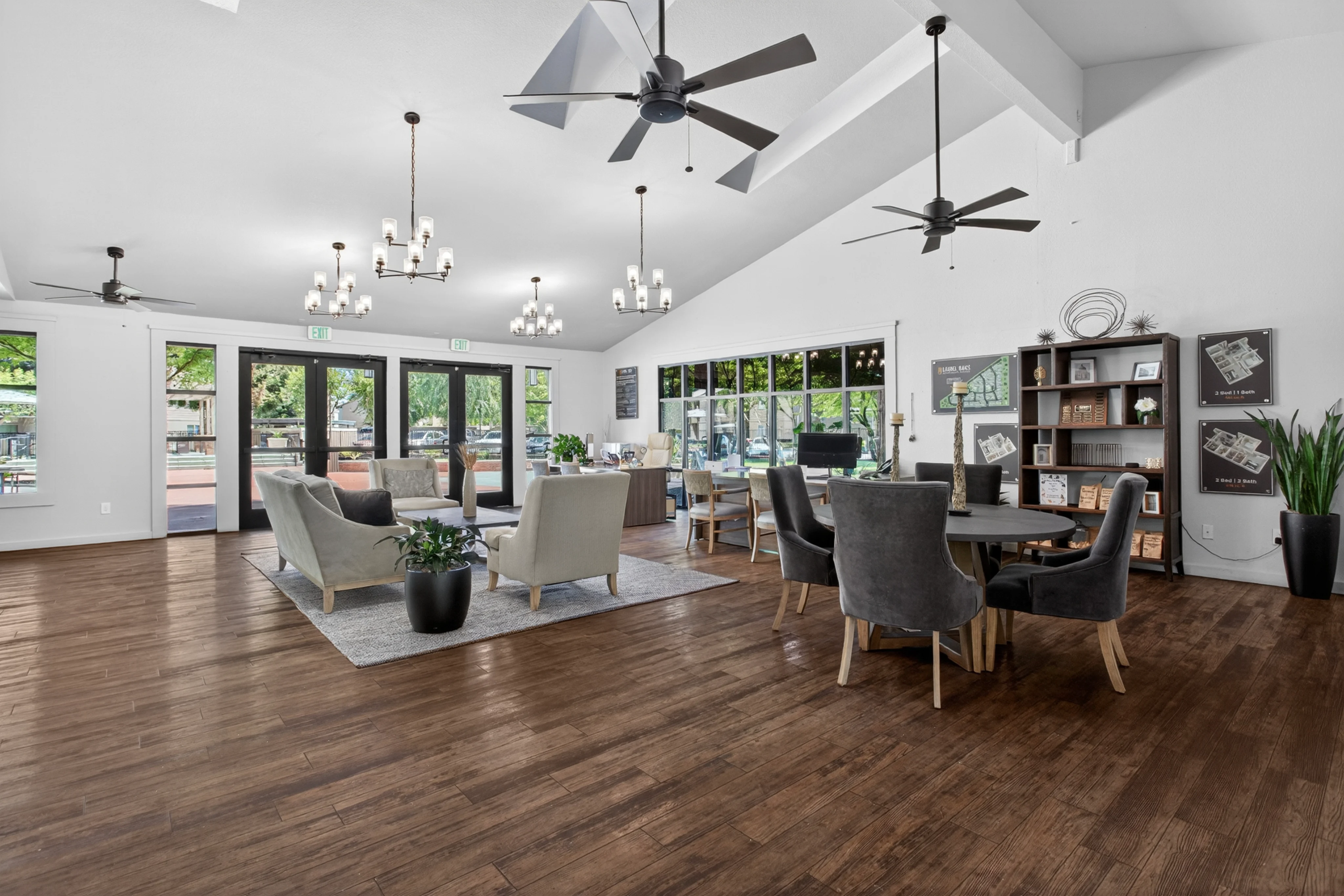 Spacious modern living area featuring high ceilings, wooden floor, and stylish furniture. Includes a large dining table and lounge seating.