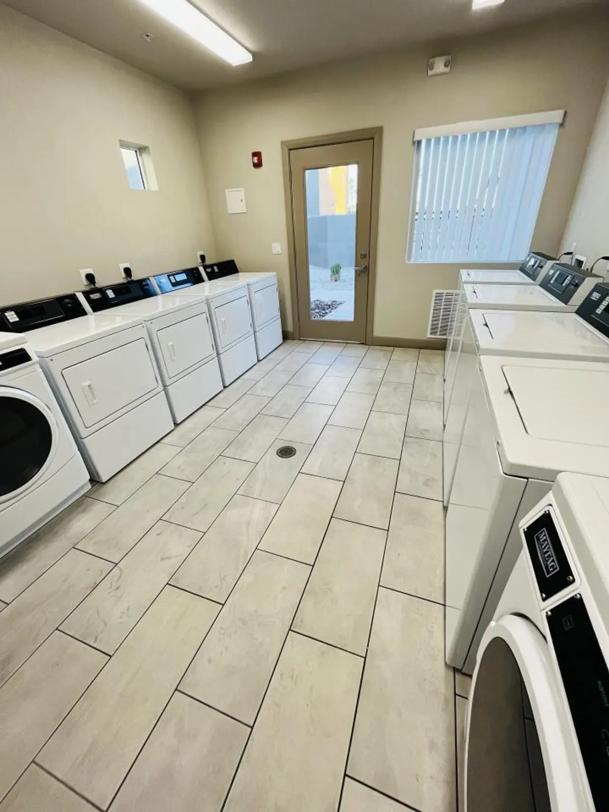 Laundry room with rows of washers and dryers.