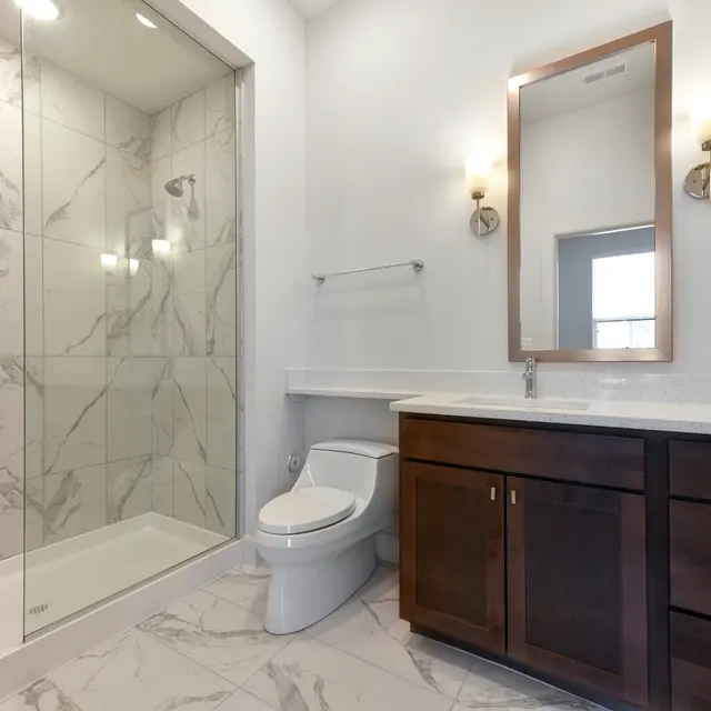 Modern Bathroom Interior A modern bathroom featuring a glass shower, a wooden vanity with a sink, and marble tiles.