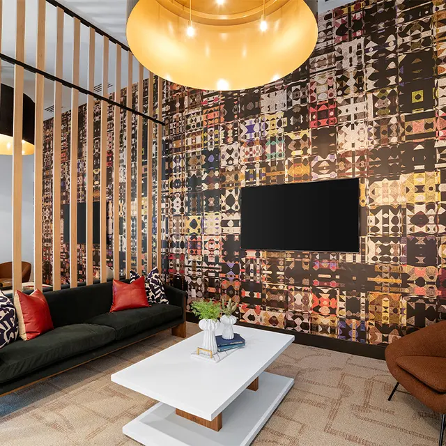 A modern living space featuring a dark patterned accent wall, a stylish coffee table, and comfortable seating arrangements.