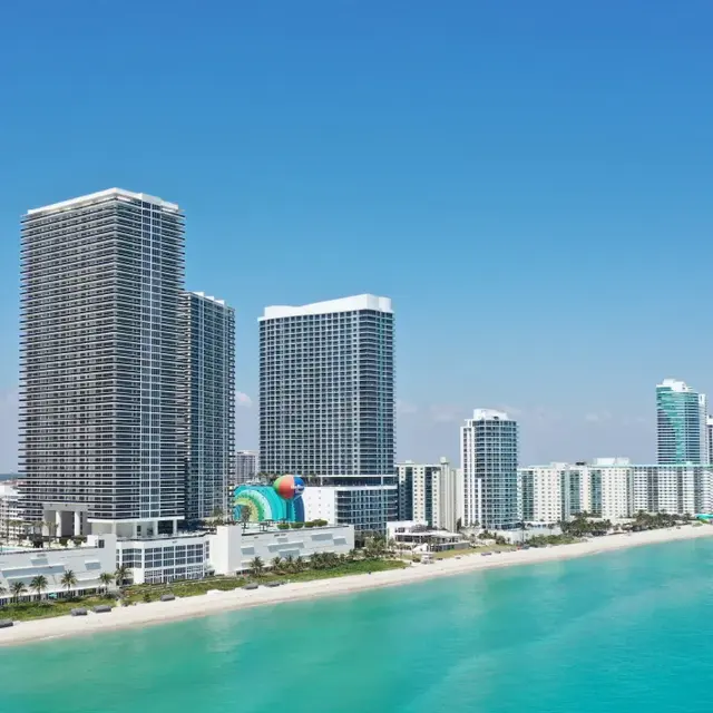 Miami Skyline and Coastline Aerial view of Miami skyscrapers and coastline with clear blue water.
